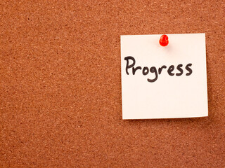 Progress note pinned to brown corkboard with red pushpin