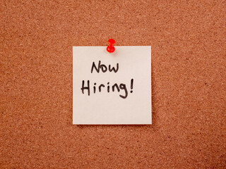 Now hiring note pinned on cork bulletin board for job vacancy announcement