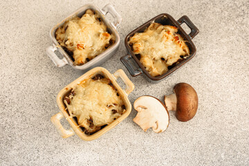 Savory baked mushroom dishes served in mini casserole dishes on a gray countertop