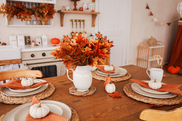 Cozy autumn dining setting with pumpkins and fall decorations in a warm kitchen