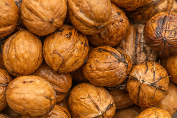 Walnut peeled kernels and whole walnuts on rustic wooden background. Healthy nuts food. Macro. Cracked shells