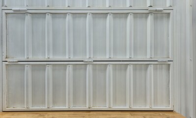 The white metal sheet window of a street food stall is closed. The white metal window is shiny. The white corrugated metal surface of the fence wall. White painted iron wall texture image.