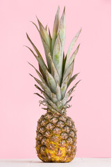 Closeup fresh juicy pineapple on a pink background. Pineapple on a wooden table