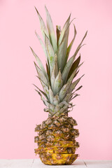 Closeup fresh juicy pineapple on a pink background. Sliced pineapple on a wooden table