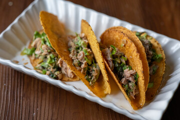 Close-up of Mexican-style tacos with ground tuna fish and vegetables