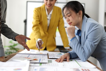 Business team analyzing financial charts and graphs, discussing company's performance and planning future strategy during a productive meeting in the office.