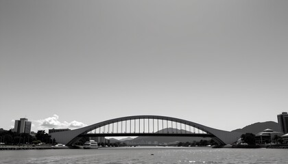 A bridge spanning across a river. The bridge has a curved design, connecting to both sides of the water body. It appears to be a modern structure with an open sided walkway