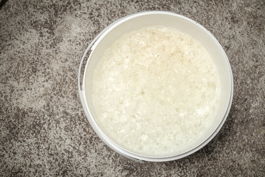 Odor neutralizer gel in large tub or bucket. Top view. Fragrance infused white gel for garbage room, basement or commercial buildings. Industrial sized room air freshener. Selective focus.