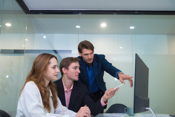 Collaborative team meeting modern office setting, showcasing three professionals engaged discussion while reviewing digital tablet. atmosphere is focused and productive, highlighting teamwork.
