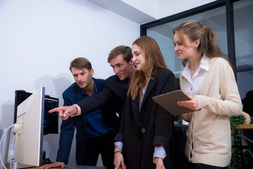 Group of four professionals giving thumbs up in modern office setting, showcasing teamwork and positivity. Their expressions reflect confidence and satisfaction with their work environment.