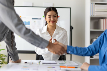 Business people shaking hands congratulating successful agreement in office meeting.
