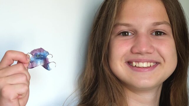 Teenage girl showing orthodontic apparatus for correcting the upper jaw. Device for dental treatment. Teeth correction, gnathology concept