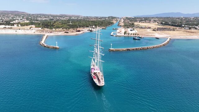 Aerial drone cinematic video of classic sailing boat crossing narrow Corinth canal of Isthmus from West submersible bridge and narrow opening of Corinthian gulf to Saronic gulf, Loutraki, Greece