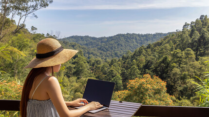 Fototapeta premium Woman in cozy orange sweater, working on laptop by window, with stunning mountain landscape in background, showcasing remote work lifestyle and tranquility