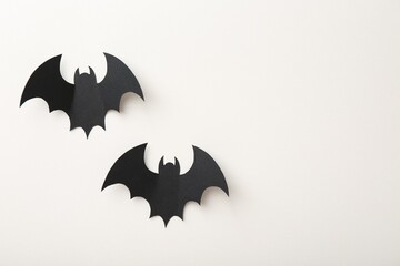 Naklejka premium Halloween decor. Black paper bats on white background, flat lay. Space for text