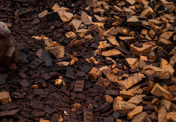 a chaotic pile of dark brown, rusted, and weathered chocolate blocks, each with intricate rectangular patterns. The blocks are scattered randomly, creating a textured, dense surface