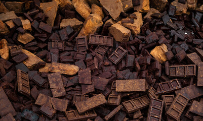 a chaotic pile of dark brown, rusted, and weathered chocolate blocks, each with intricate rectangular patterns. The blocks are scattered randomly, creating a textured, dense surface