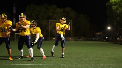 American football quarterback throwing a pass during a night game - Powered by Adobe