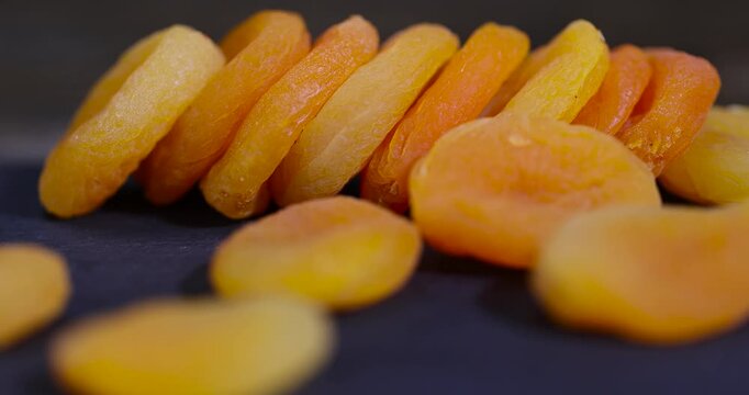 dried ripe apricot fruits on a black slate board, dried seedless pure dried apricots for long-term storage and used as a sweet or for making compotes