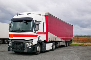 The white truck and red container Stop on rest area station near highway