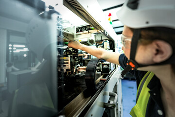 In an Industry 4.0 smart factory, an engineer uses a tablet to run an AI machine vision algorithm on a collaborative robot cobot, optimizing production via a real time digital twin.