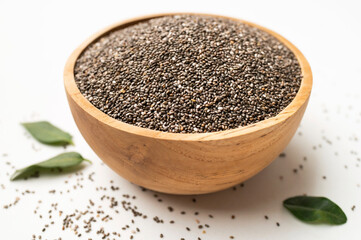 Chia seeds in wooden bowl on white background. Healthy seeds for desserts, healthy eating, antioxidant, and superfood rich in omega-3 fats, protein, vitamins and minerals