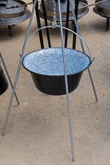 Empty metal enamelled cauldron pot outdoors on countryside