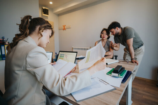 A couple consults with a financial advisor in a bank setting, discussing loans and financial planning while reviewing documents and digital data for informed decision-making regarding their finances.