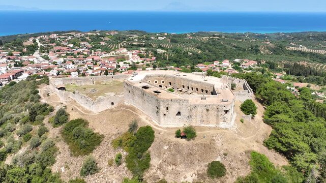 Aerial drone cinematic video of Frankish Castle of Chlemoutsi in area of Kylini overlooking small village of Kastro and deep blue sea, Peloponese, Ilia, Greece