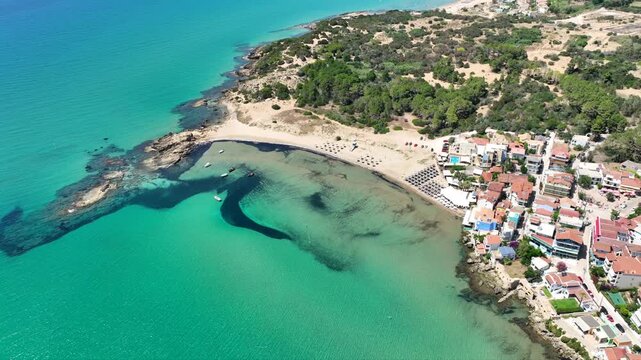 Aerial drone cinematic video of small seaside village and circular sandy beach of Arkoudi in Western Peloponnese, Ilia prefecture, Greece