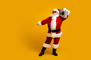 Santa Claus grooving to beats on a boombox while wearing a cheerful red costume on a vibrant yellow background celebrating Christmas