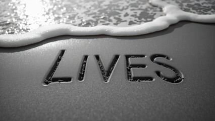 Sand writing with word LIVES near ocean waves creates serene and reflective atmosphere