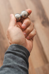 CNC spheres in a man's hand, daylight highlights their form. A symbol of two poles and the force that holds them. A vision of power, balance, and precision.