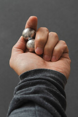 CNC spheres in a man's hand, daylight highlights their form. A symbol of two poles and the force that holds them. A vision of power, balance, and precision.