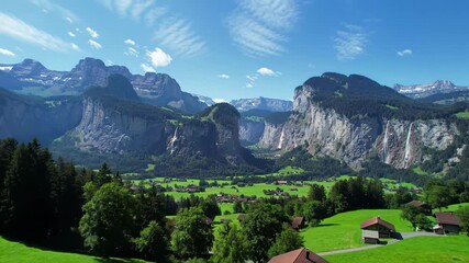 Cinematic drone video ascends over verdant Swiss Alps, revealing Lauterbrunnen Valley, towering cliffs, cascading waterfalls, and snow-capped peaks. Profound tranquility and natural beauty - Powered by Adobe