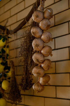 Bundles of onions, garlic, lemons and dried herbs hang on the kitchen wall