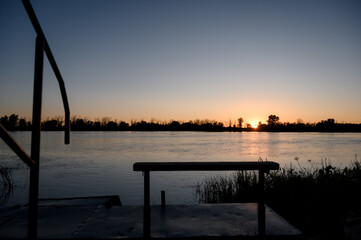 A pontoon deck or pier with a metal frame and railings near the water