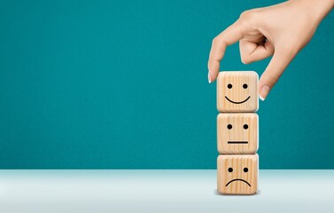Hand choosing wooden block with face image