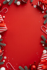 Vertical holiday scene with a bold red backdrop framed by evergreen branches, striped gift boxes,...