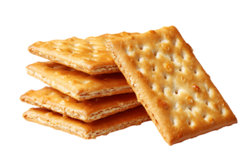Close up of golden saltine crackers stacked on white background, showcasing their crispy texture and perforations