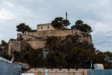 The historic Denia Castle stands majestically atop a hill, bathed in the warm sunlight.