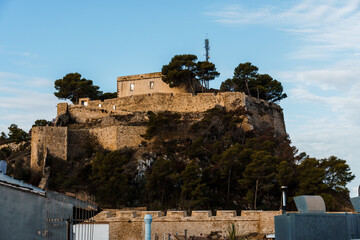 The historic Denia Castle stands majestically atop a hill, bathed in the warm sunlight.