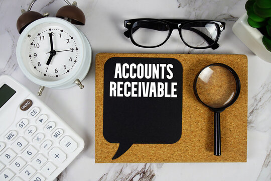 Accounts Receivable text with Calculator, alarm clock and magnifying glass on marble background