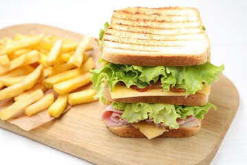 Tasty sandwich served with french fries on white table, closeup