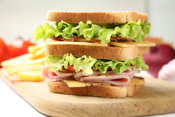 Tasty sandwich served with french fries on white table, closeup