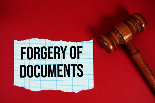 Forgery of documents text written on rip paper with wooden judgment gavel on red background