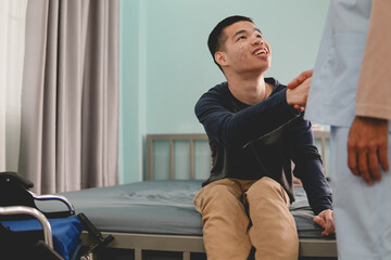 A mental health young man in wheelchair and doctor or physical therapist's or caregiver providing...