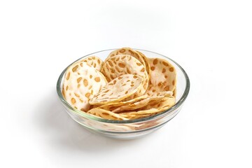 Keripik Tempe or Tempeh Chips in glass bowl. Isolated on white background with copy space. Traditional Indonesian food are made from soybeans mixed with rice flour then sliced ​​thinly.