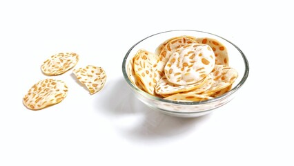 Keripik Tempe or Tempeh Chips in glass bowl. Isolated on white background with copy space. Traditional Indonesian food are made from soybeans mixed with rice flour then sliced ​​thinly.