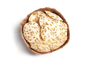 Top view of Keripik Tempe or Tempeh Chips in bamboo basket. Isolated on white background with copy space. Traditional Indonesian food are made from soybeans mixed with rice flour then sliced ​​thinly.